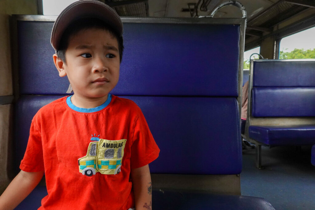 เด็กนั่งอยู่บนรถไฟไทย